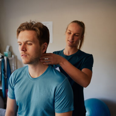 Young woman giving neck massage to man